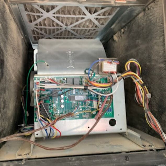 Dirty Inside view of an air duct cleaning system showing electronic components and wiring.